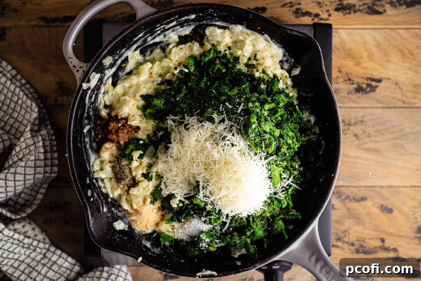 Adding spinach, cheese, and seasonings to cream sauce.