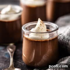 Chocolate pot de creme served in a glass jar with whipped cream on top.