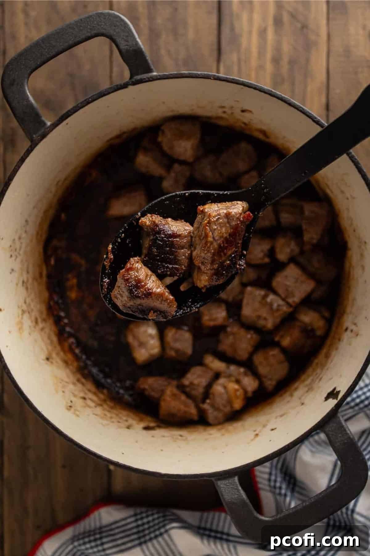 Beautifully browned beef chunks in a pot, ready to be removed.