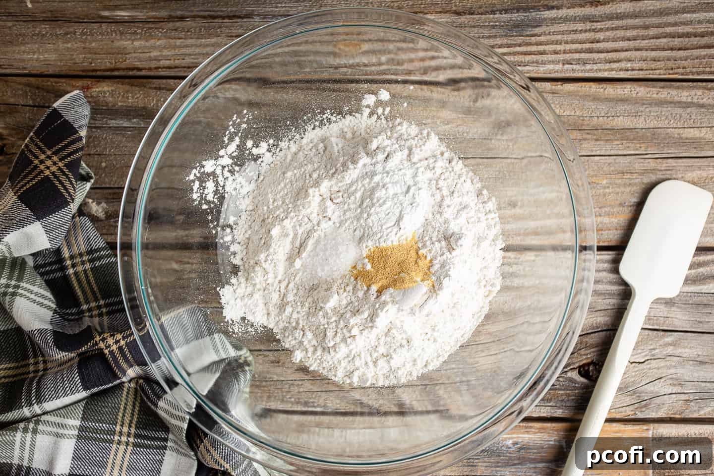 Dry ingredients for making beer bread in a large glass mixing bowl.
