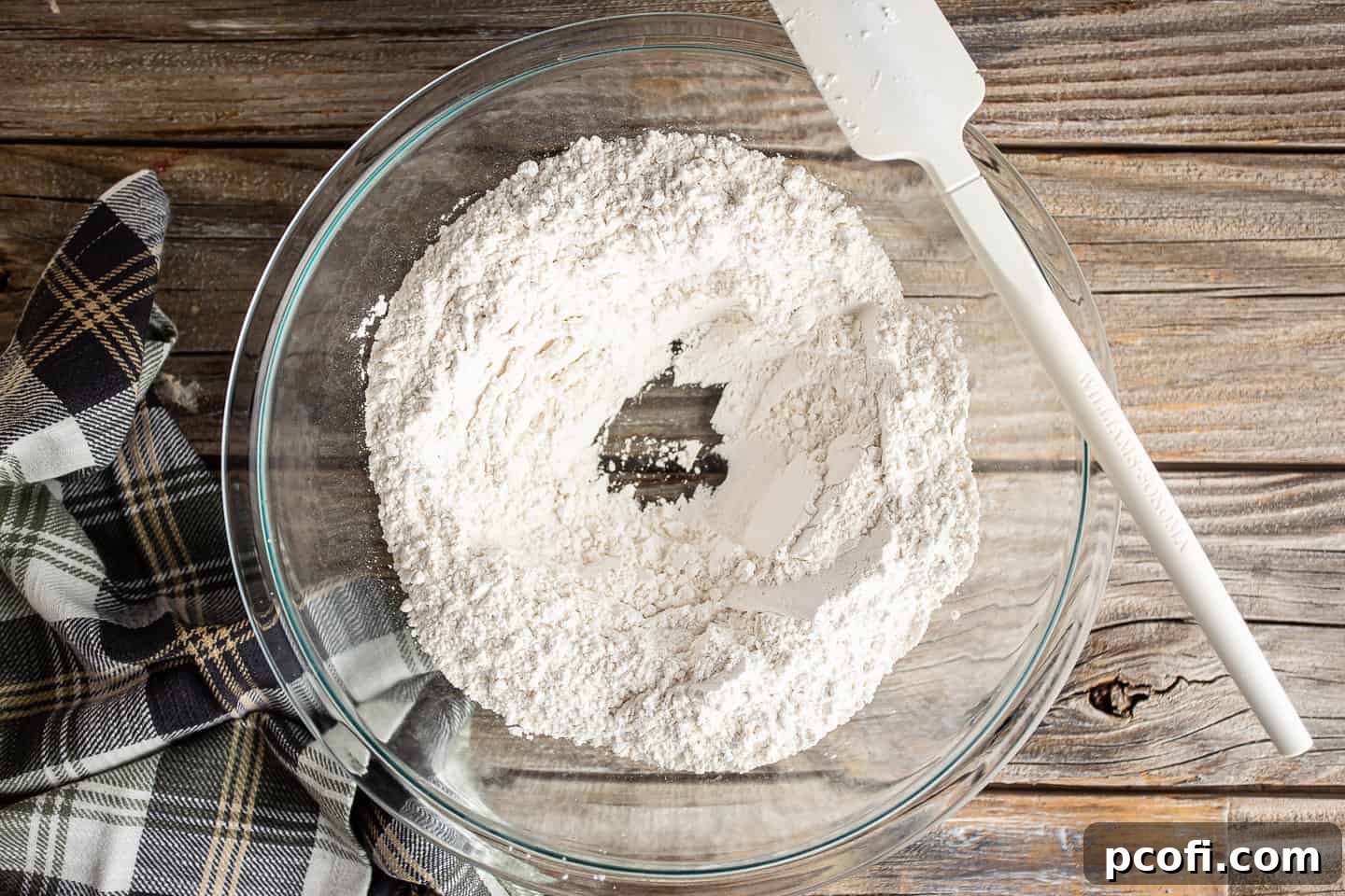 Making a well in the center of the dry ingredients.