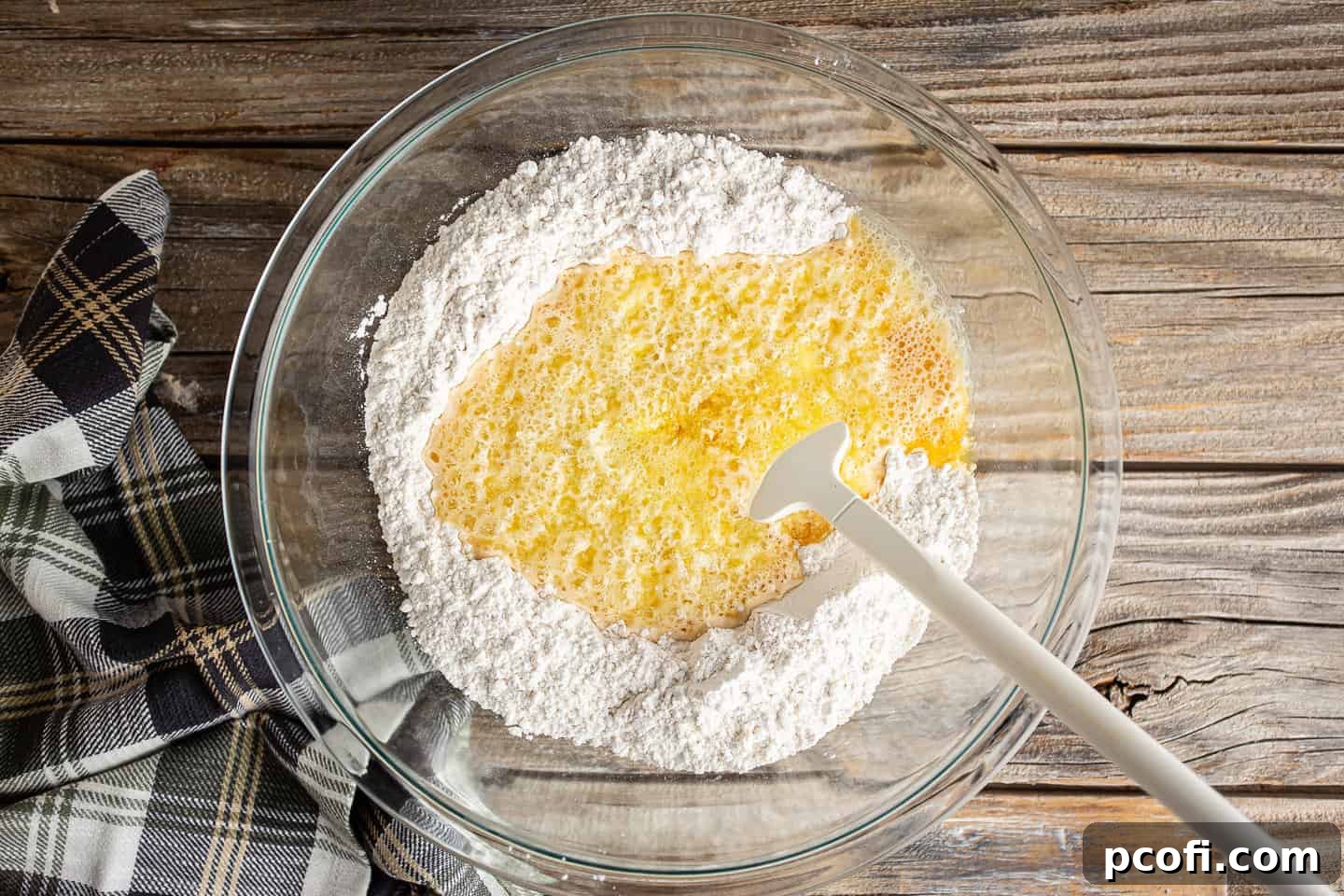 Adding beer, melted butter, and honey to the dry ingredients.