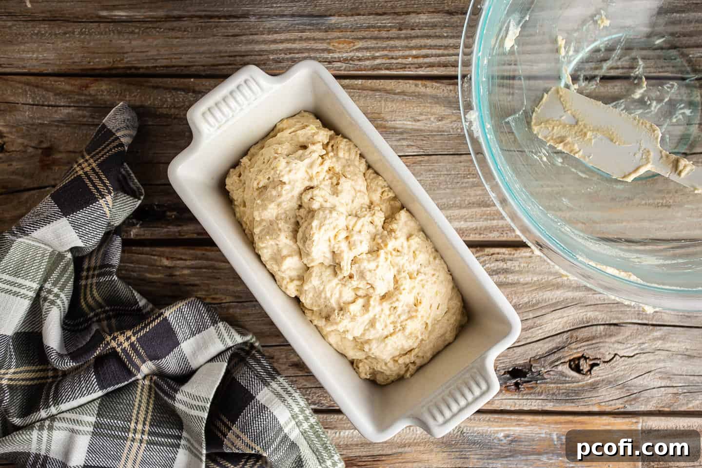 Transferring beer bread dough to a loaf pan.