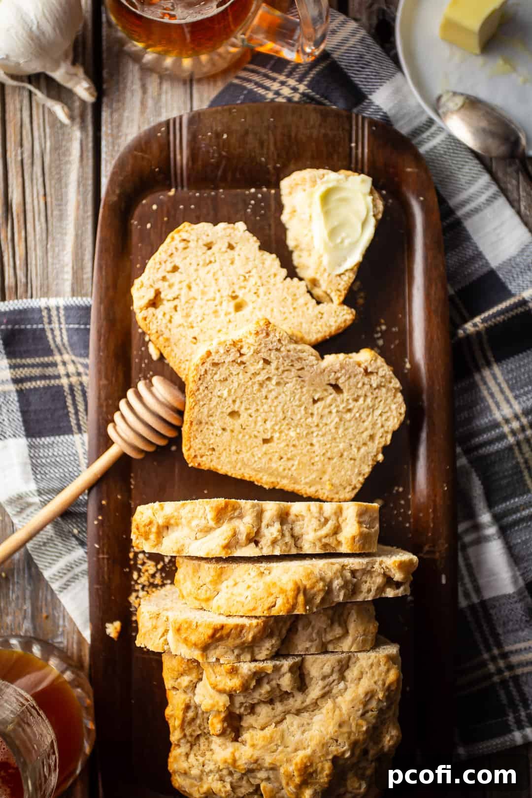 Recipe for beer bread, prepared, sliced, buttered, and served on a wood tray.