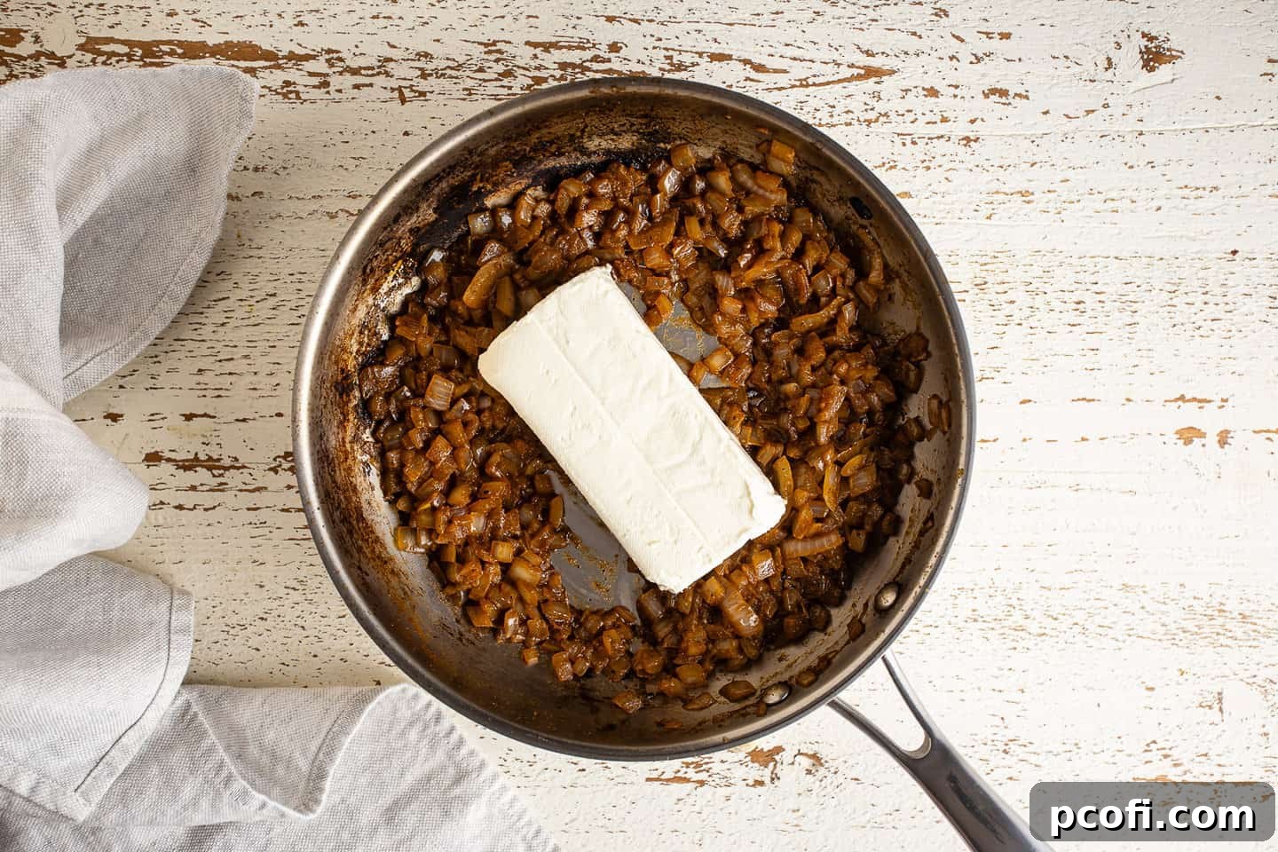 Adding cream cheese to caramelized onions.