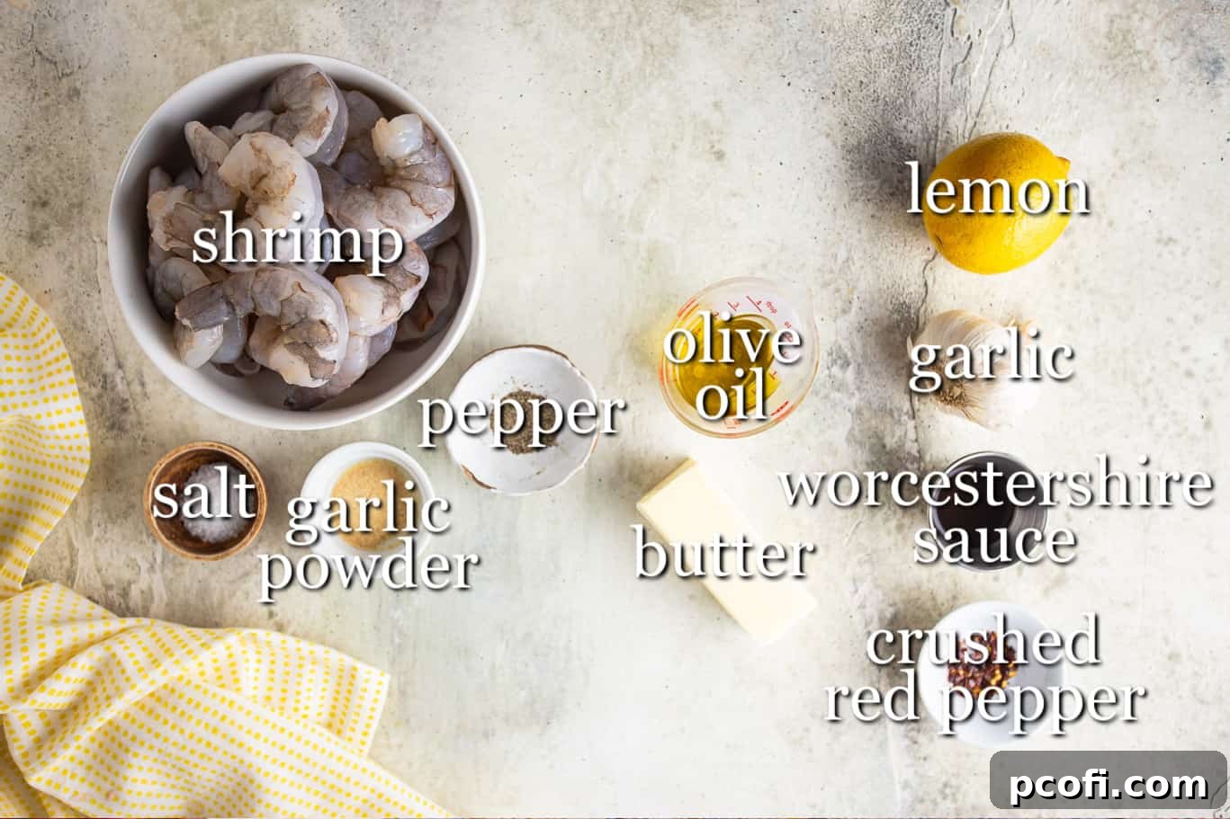 A curated display of fresh ingredients for shrimp scampi: large shrimp, fresh lemons, garlic cloves, butter, olive oil, and various spices.