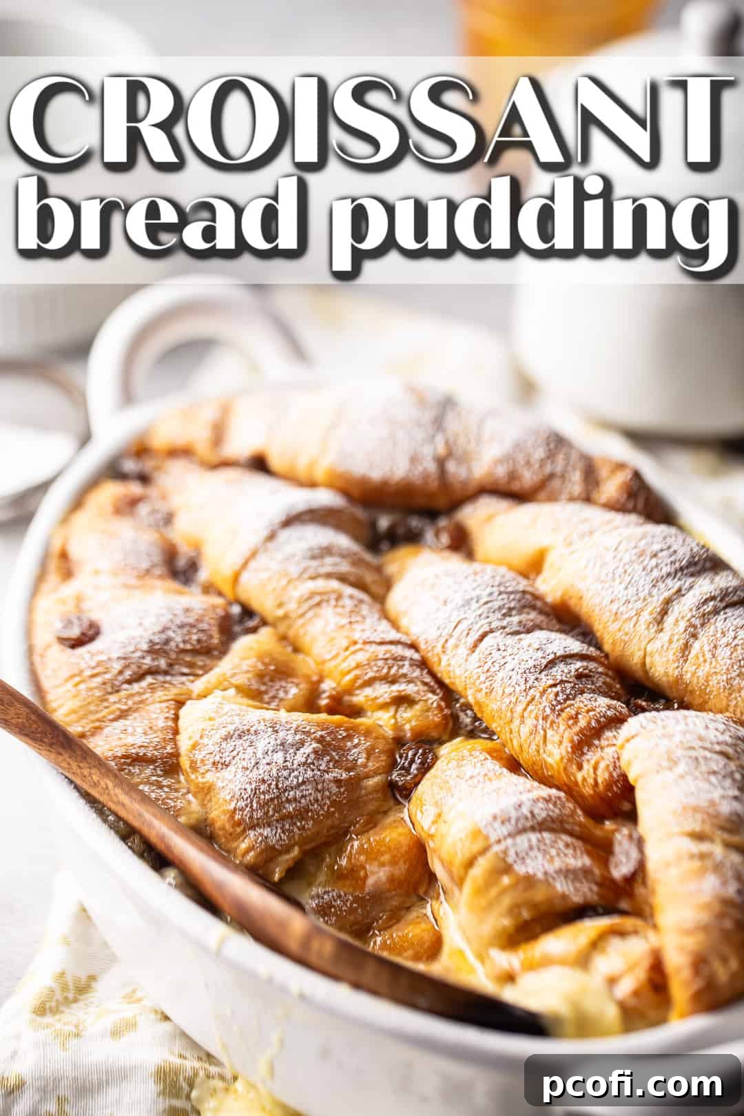 Croissant bread pudding recipe, prepared and presented on a white background with a dusting of powdered sugar.