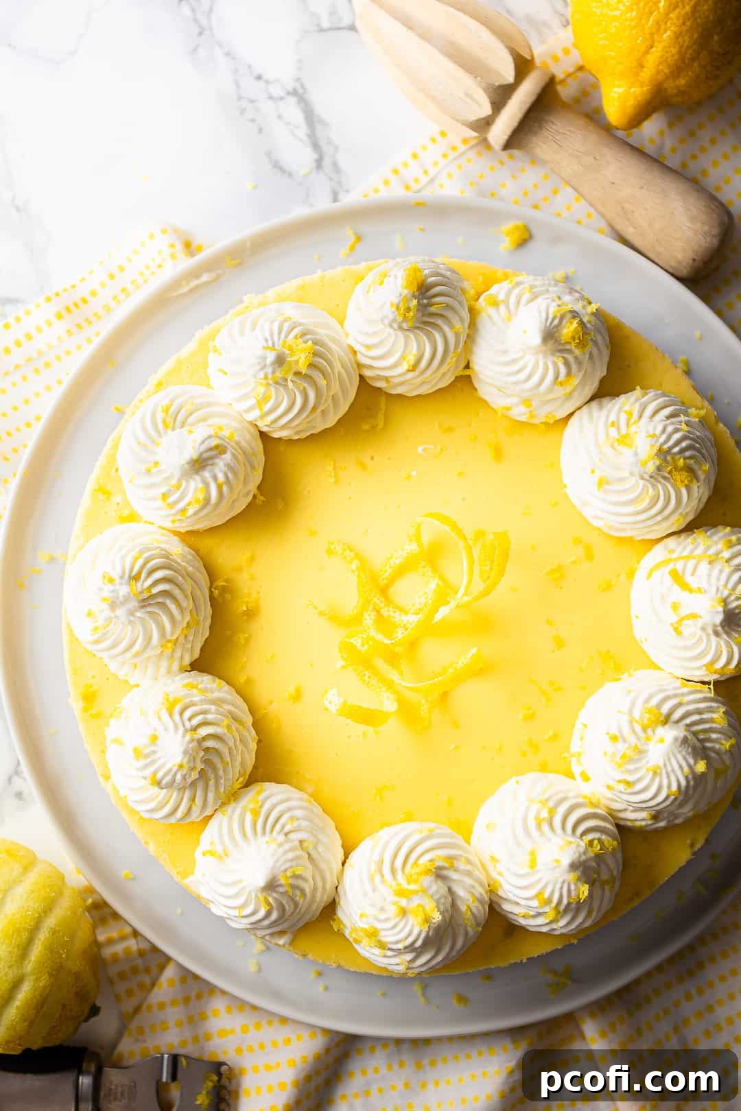 Lemon cheesecake adorned with elegant swirls of whipped cream and delicate curls of lemon zest, ready to be served.