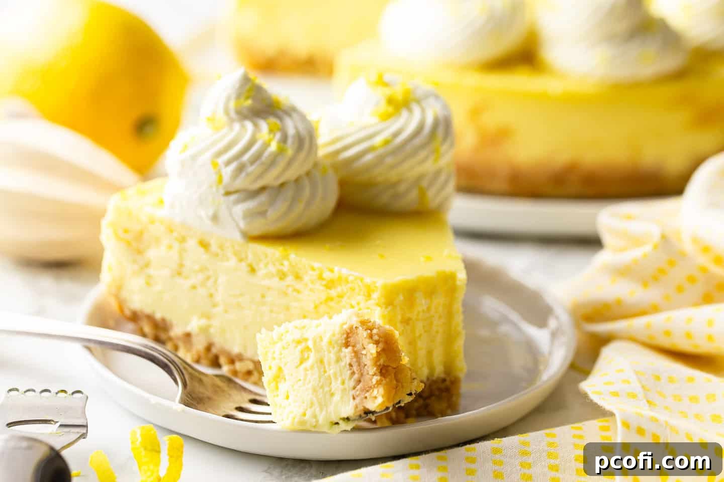 Best lemon cheesecake recipe, perfectly sliced and served with a bite taken out, showcasing its creamy interior and crisp crust.