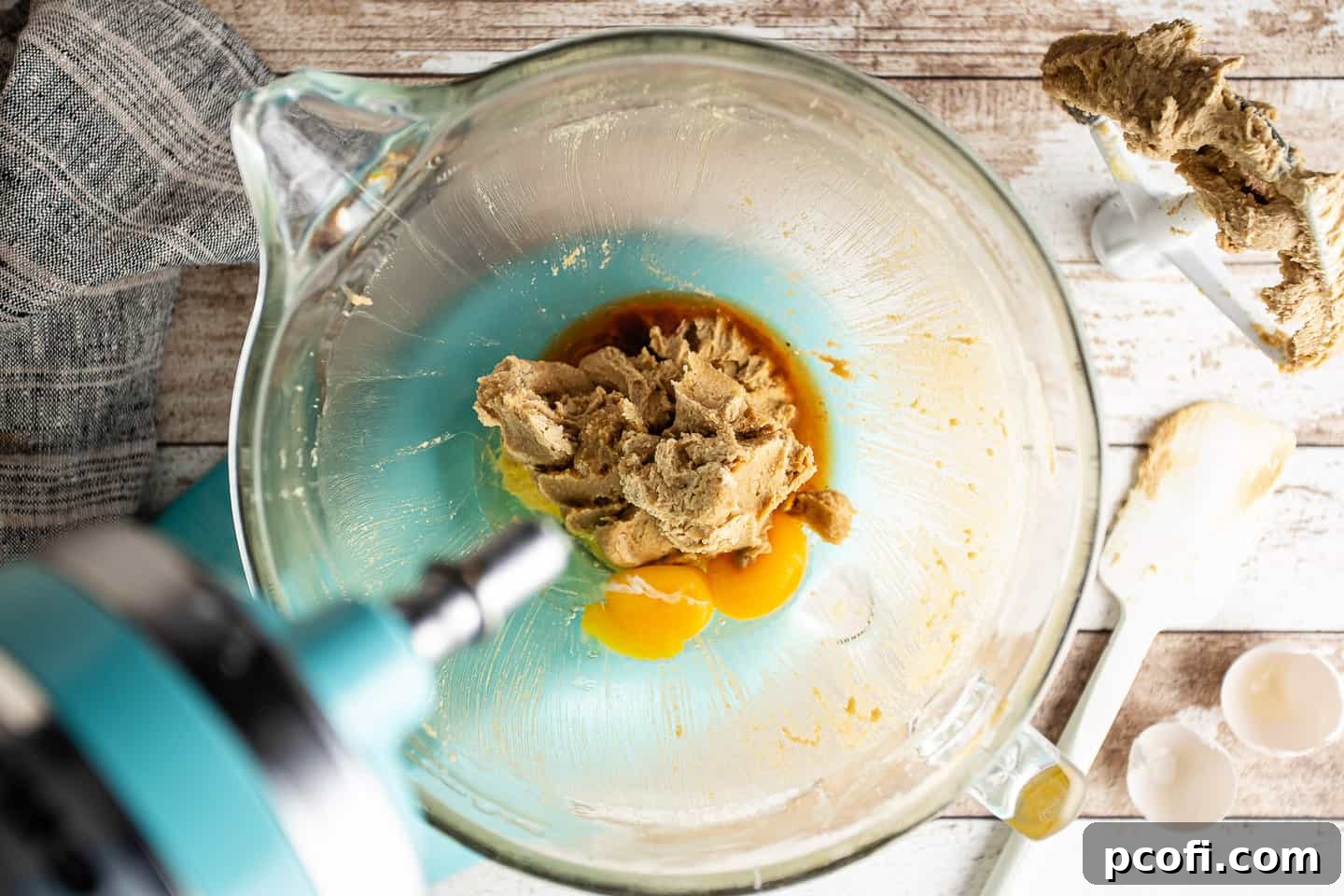 Adding eggs and vanilla to the creamed butter and sugar mixture for the skillet cookie dough.