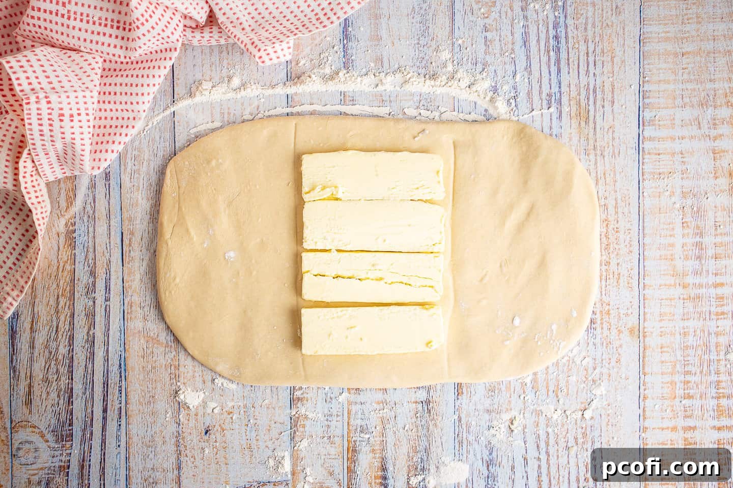 Danish dough rolled into a rectangle with the first layer of butter slabs placed in the center.