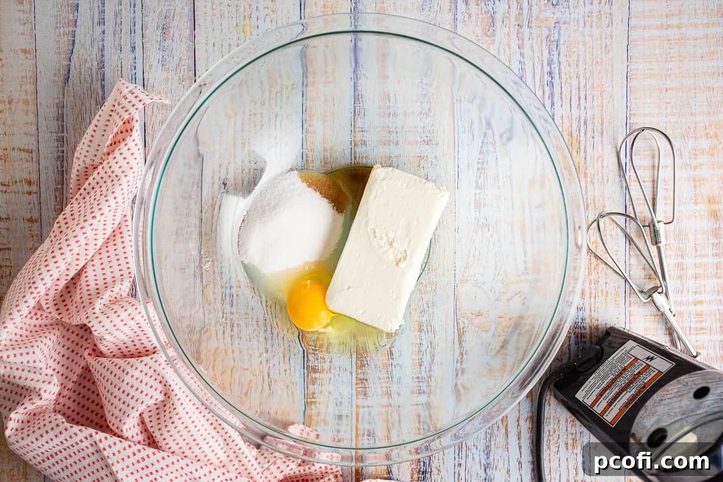 Ingredients for cream cheese filling in a mixing bowl, ready to be blended.