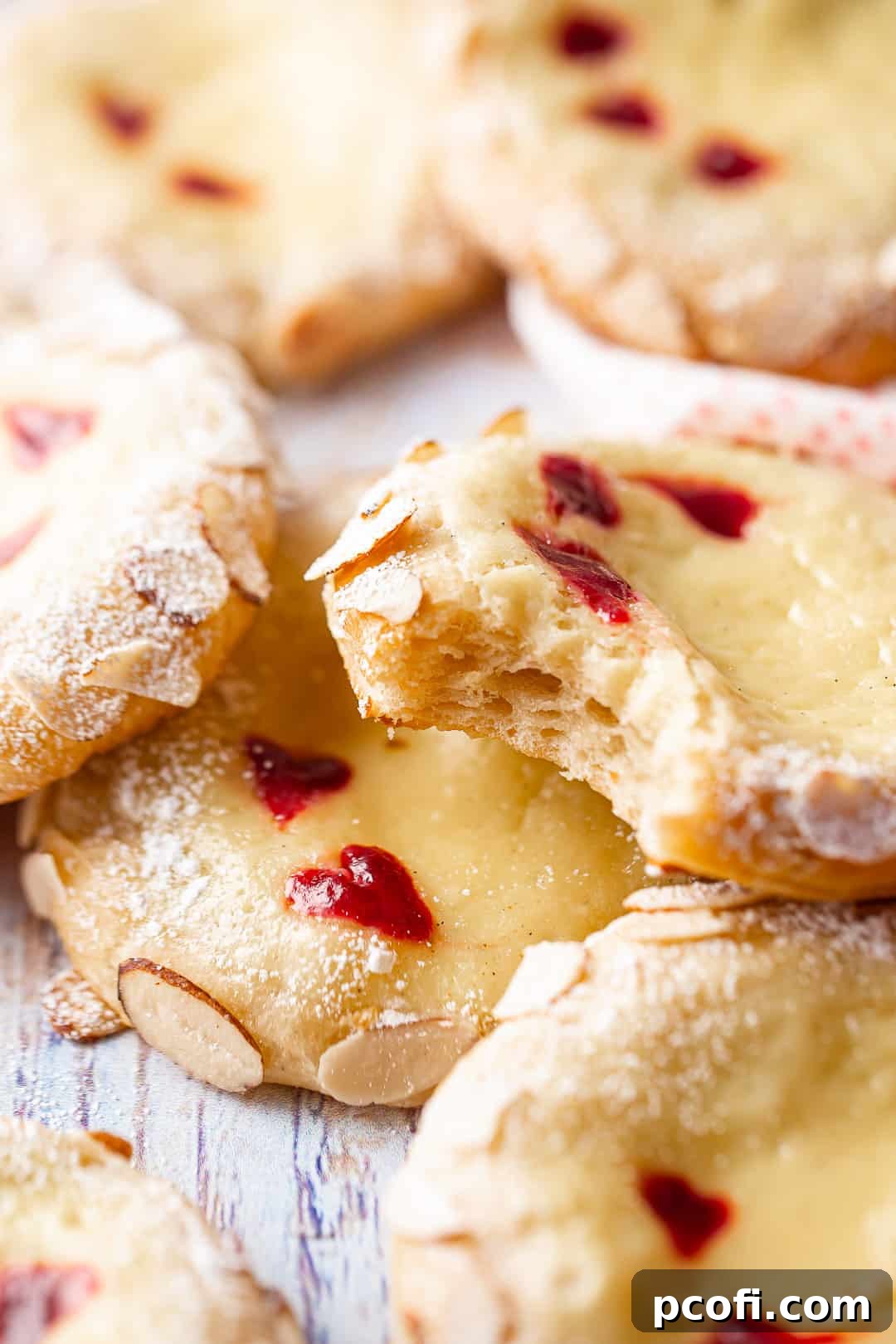 A baked Cheese Danish with a bite taken out, revealing the numerous flaky layers of the pastry.