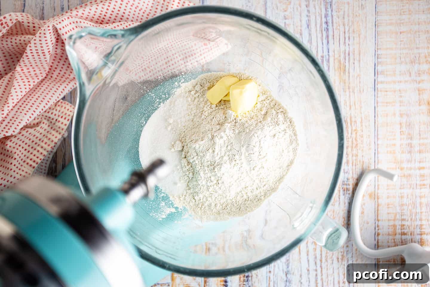 Dry ingredients for Danish dough mixed with butter, forming coarse crumbs in a stand mixer bowl.