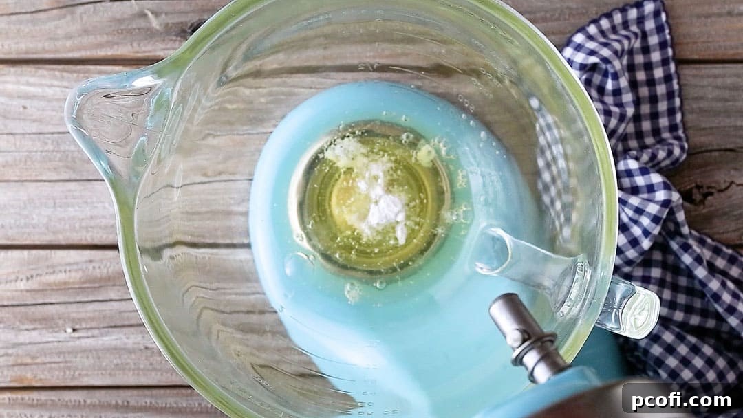 Egg whites, cream of tartar, and salt ready in a large, clean glass mixing bowl, poised for whipping into a light meringue.