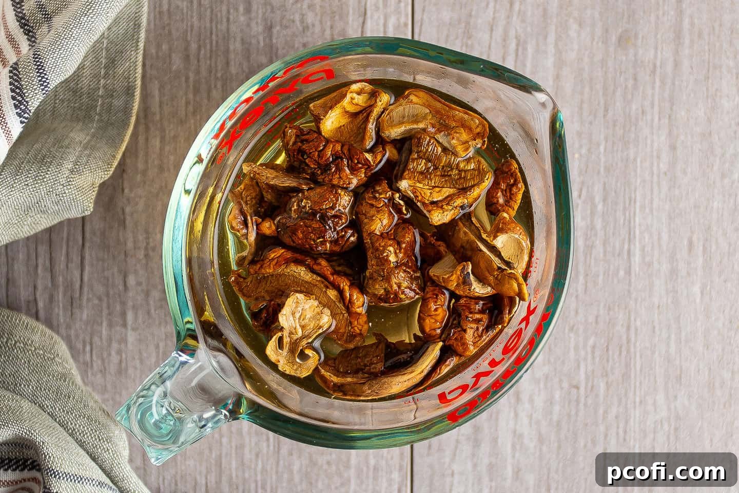 Dried mushrooms soaking in a bowl of hot water, beginning the rehydration process.
