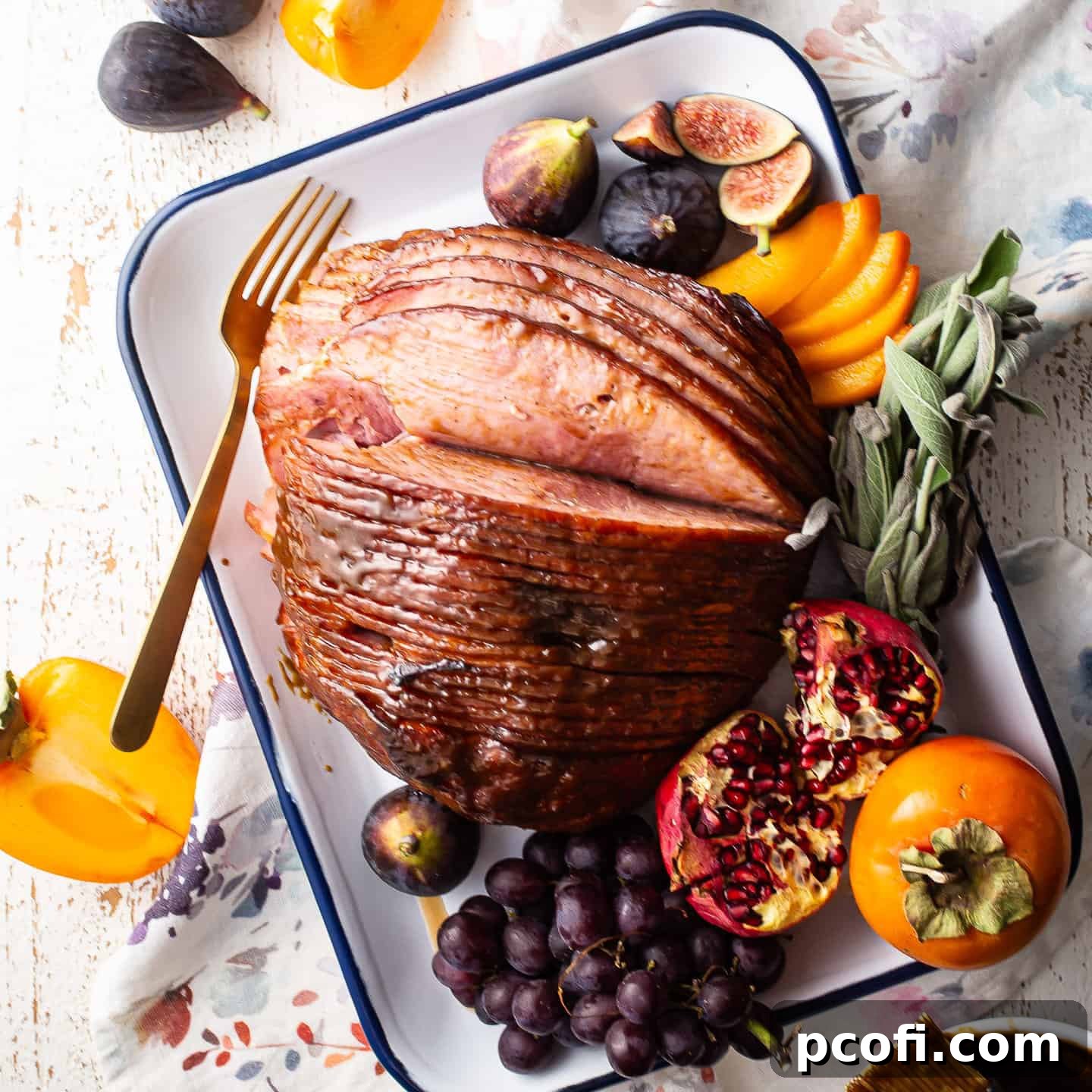 A spiral-sliced ham with a glistening brown sugar glaze, perfectly cooked and presented on an elegant enamelware tray, ready for serving.