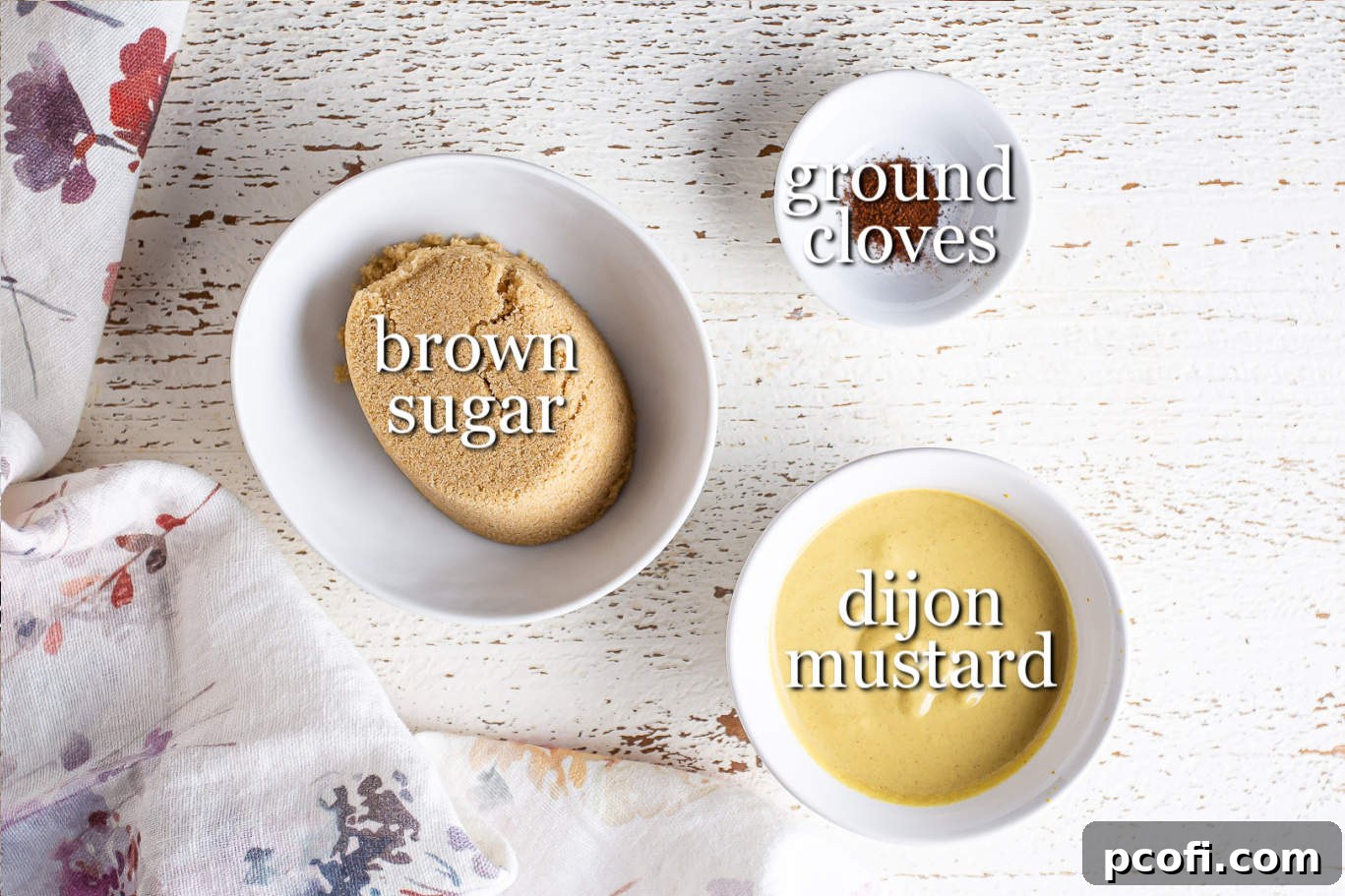 The three essential ingredients for ham glaze laid out: brown sugar, Dijon mustard, and ground cloves, with clear text labels.