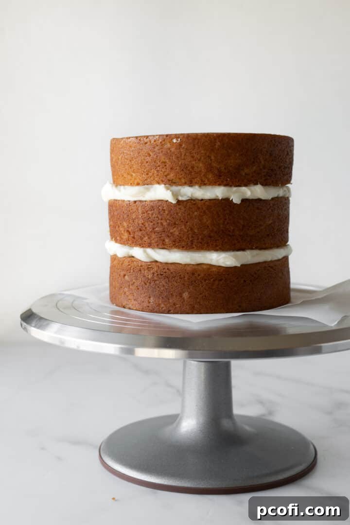 Layering the orange cake with cream cheese frosting in between.