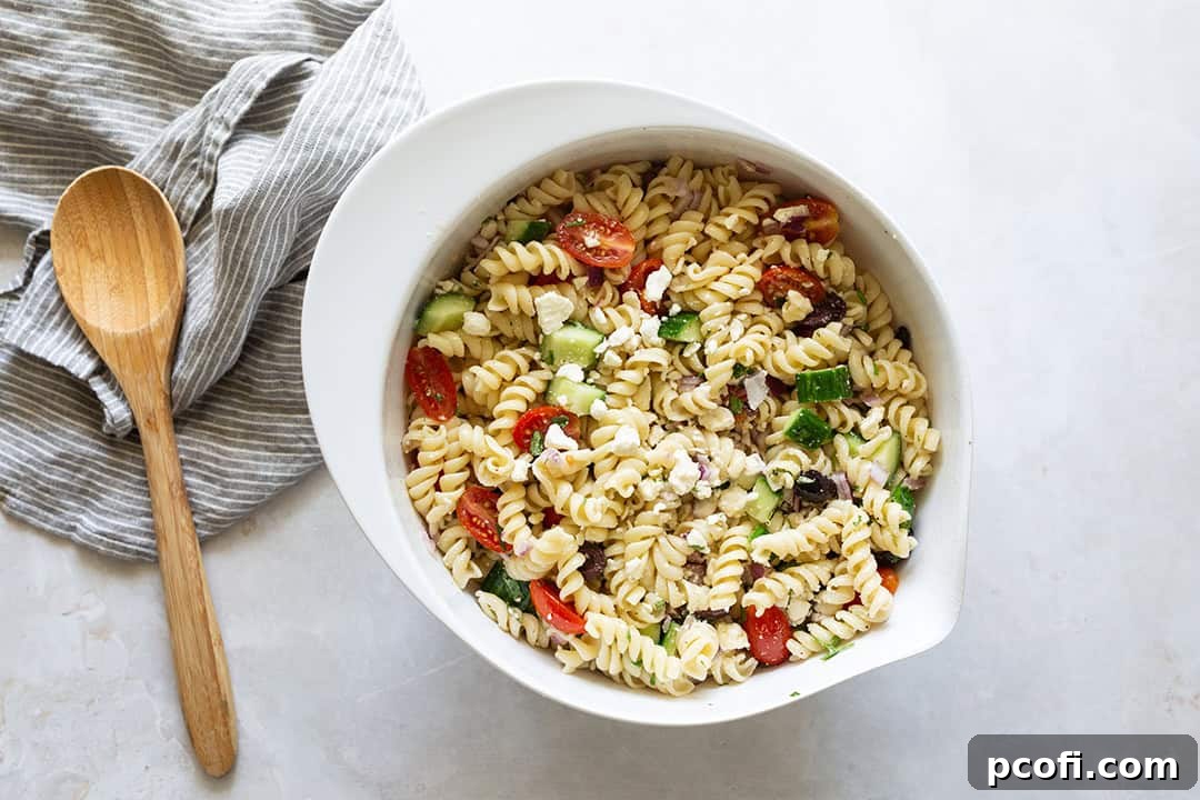Greek pasta salad perfectly mixed together in a large serving bowl, ready to be enjoyed.