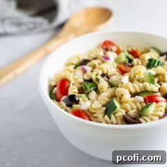 Close up of Greek pasta salad in a bowl, showcasing its fresh ingredients and vibrant colors.