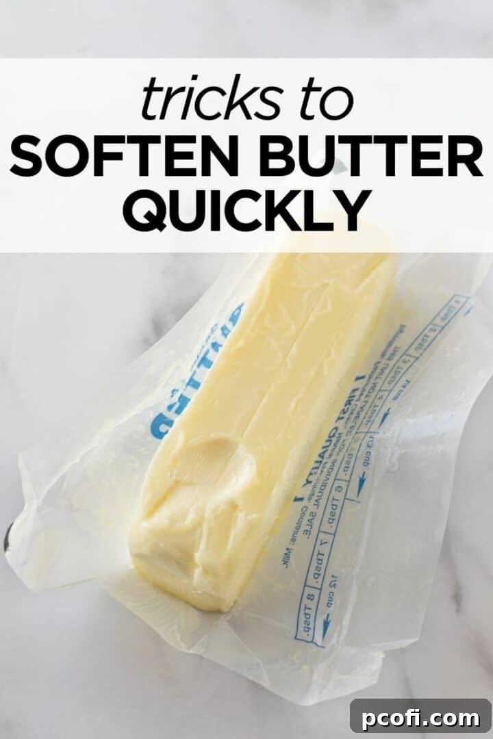 A stick of room temperature butter with a finger indentation, demonstrating perfect softness for baking.