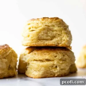 Two fluffy buttermilk biscuits stacked on a white table, ready to be enjoyed.