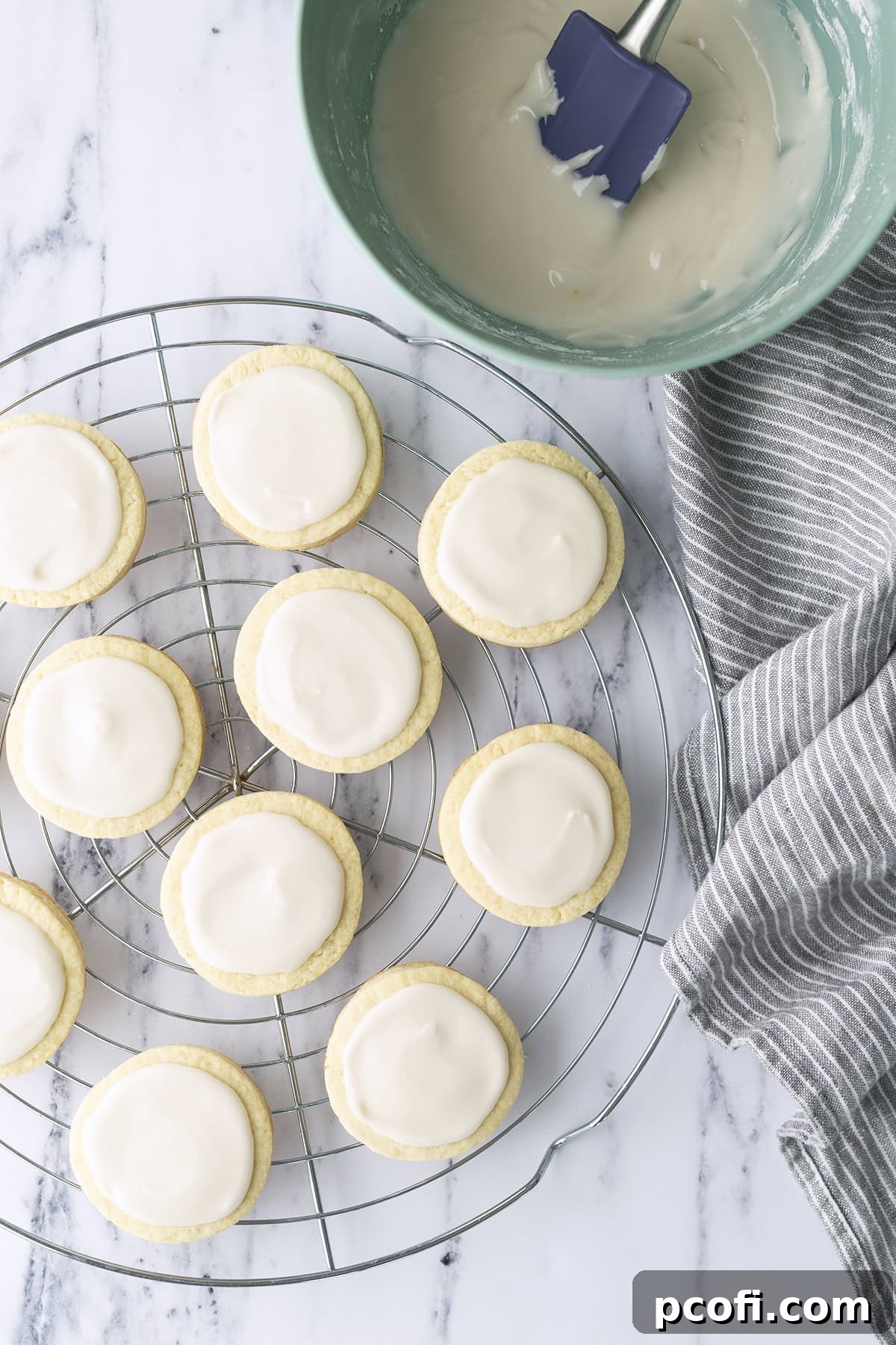 Delicious vanilla glaze generously spread on freshly baked cookies, ready to be enjoyed.