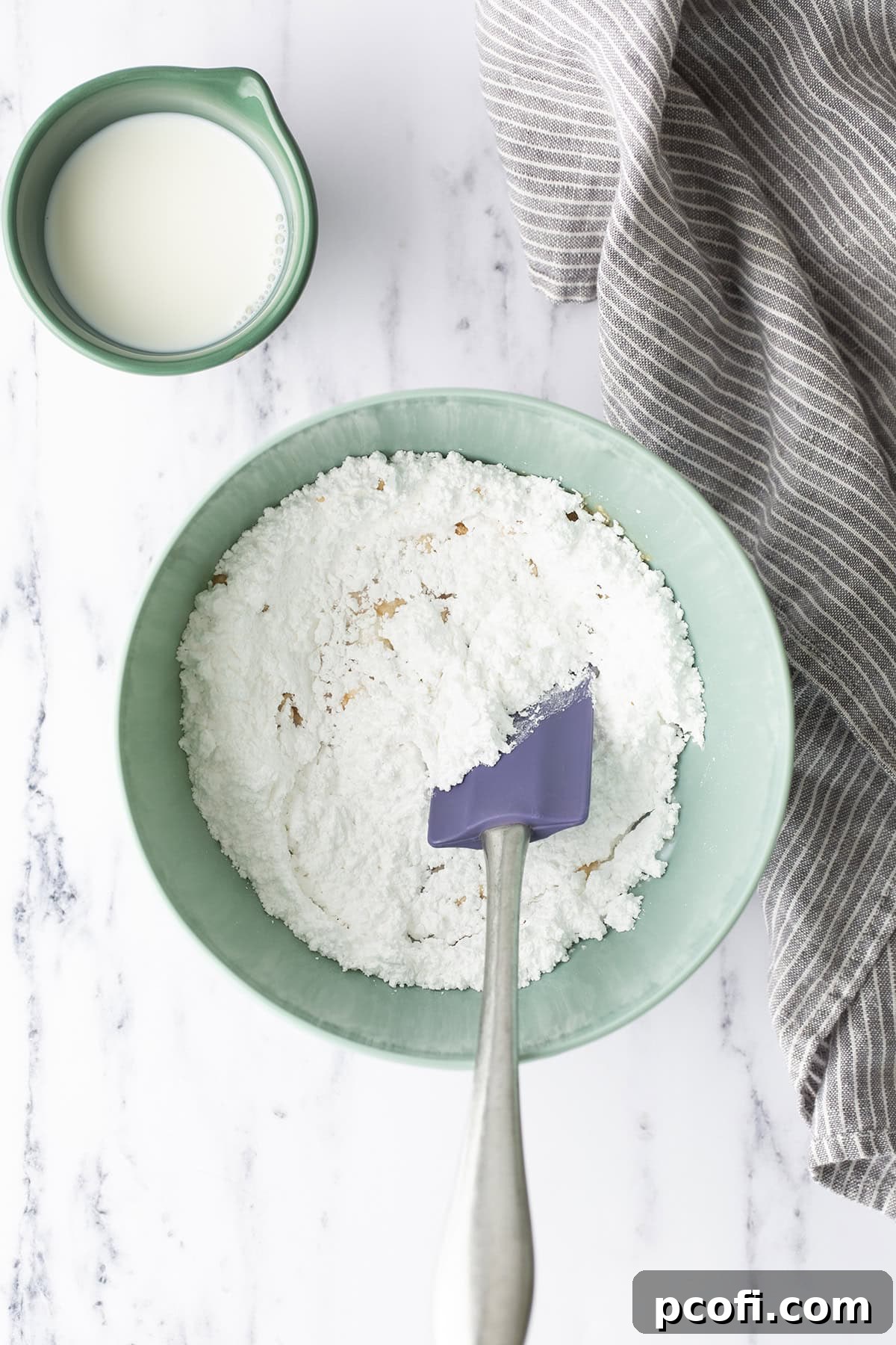 Vanilla glaze ingredients in a bowl before mixing, showing powdered sugar, milk, and vanilla.