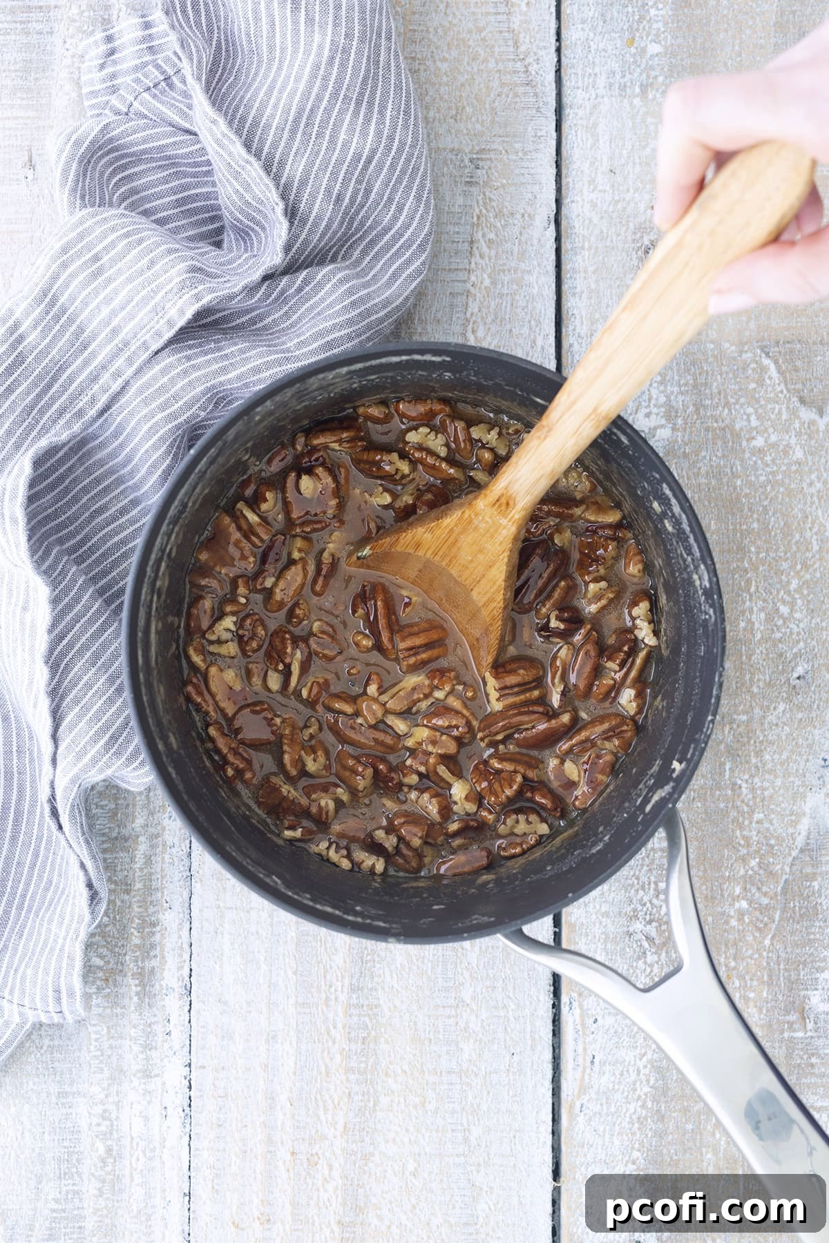 Stirring pecans into the thickened praline mixture