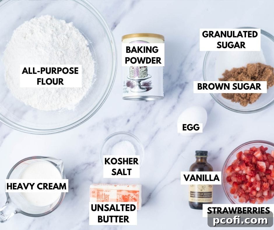 A collection of fresh ingredients laid out for making strawberry scones, including flour, sugars, butter, strawberries, and cream.