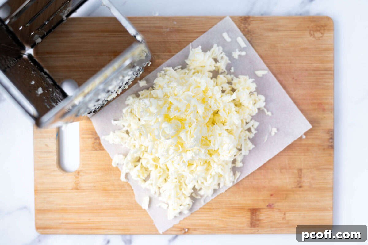 Frozen butter grated onto a parchment-lined cutting board, ready to be added to the dry ingredients.