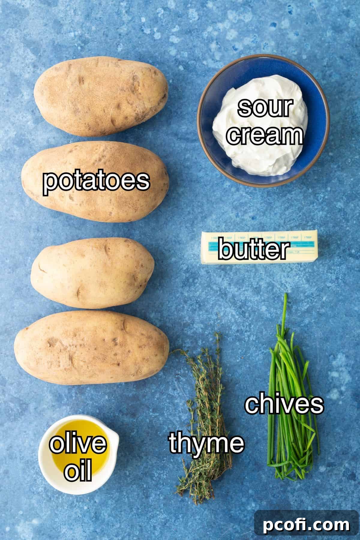 Various ingredients for twice-baked potatoes laid out: Russet potatoes, olive oil, sour cream, butter, chives, thyme, rosemary, salt, and pepper.