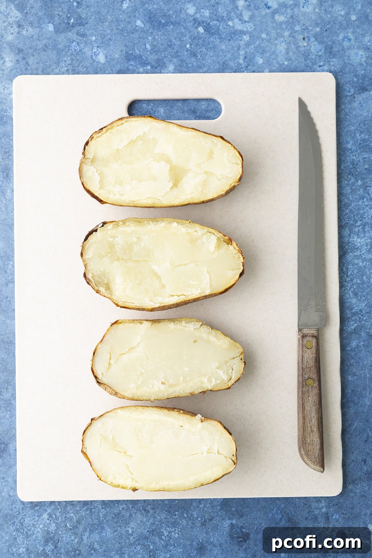 Baked potatoes cut in half lengthwise, showing the fluffy interior