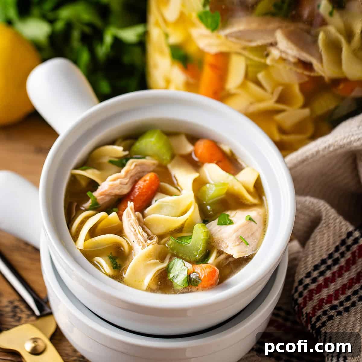 A comforting bowl of homemade chicken noodle soup, brimming with tender chicken, noodles, and vegetables in a savory broth.