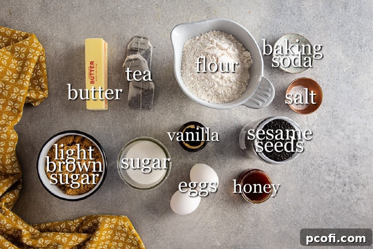 Separate containers of ingredients laid out for making earl grey black sesame cookies, including butter, sugars, flour, and black tahini.