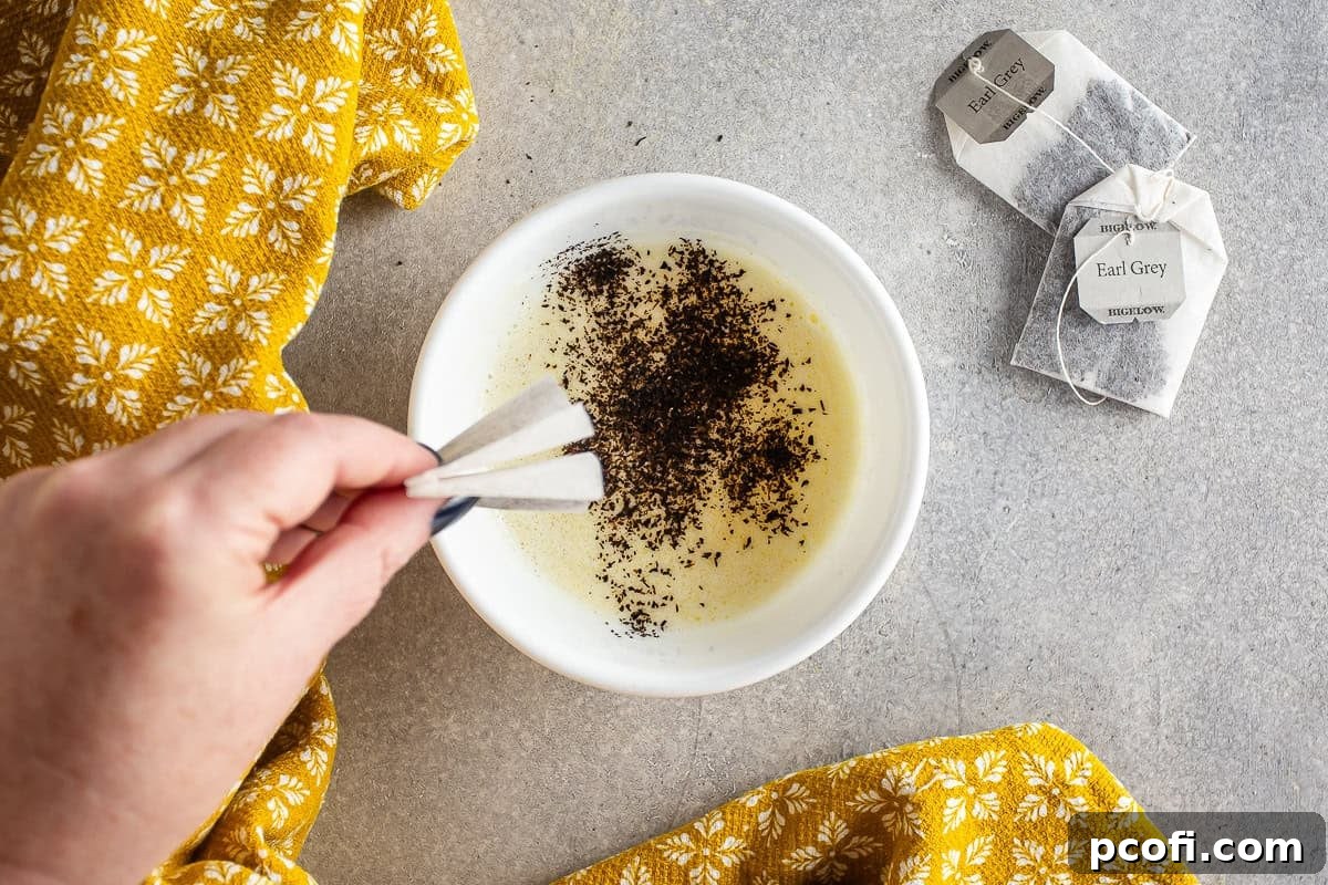 Melted butter with Earl Grey tea leaves infusing, stirring gently in a bowl.