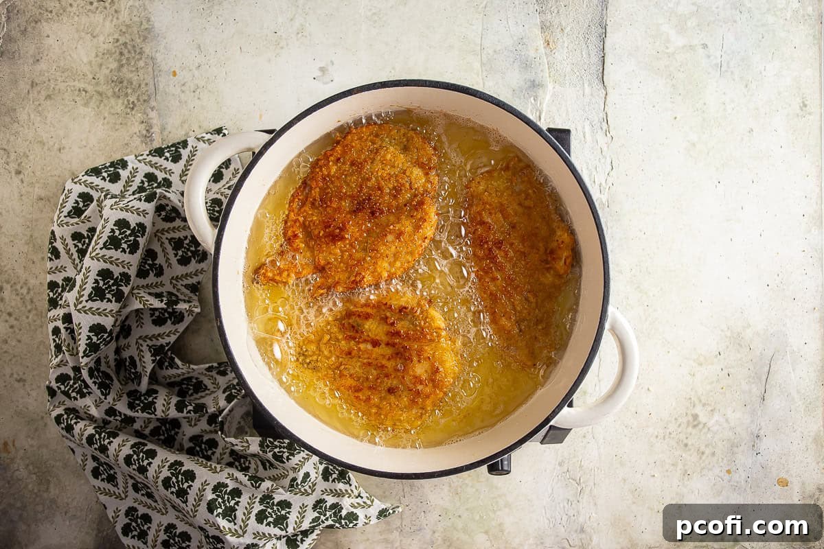 Golden brown chicken cutlets being fried.