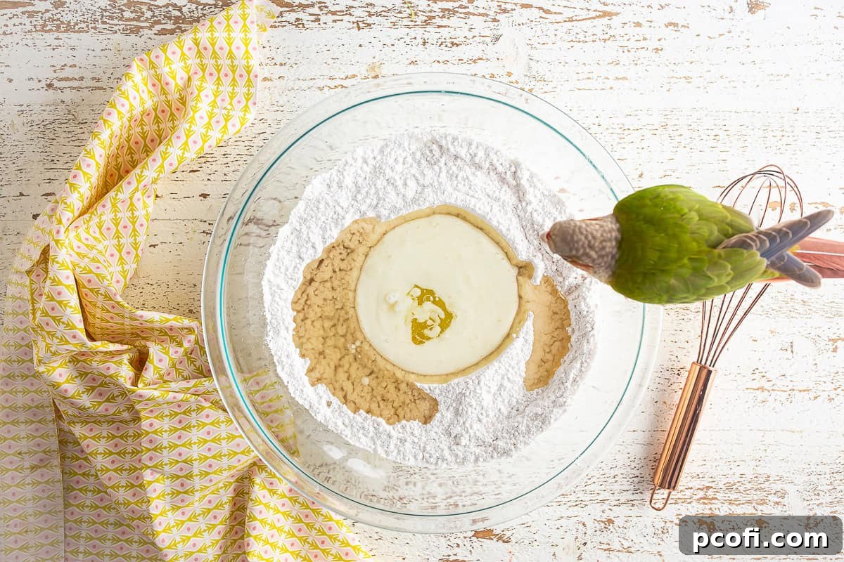 Adding liquid ingredients to the center of the dry ingredients in a bowl for the loaf batter.