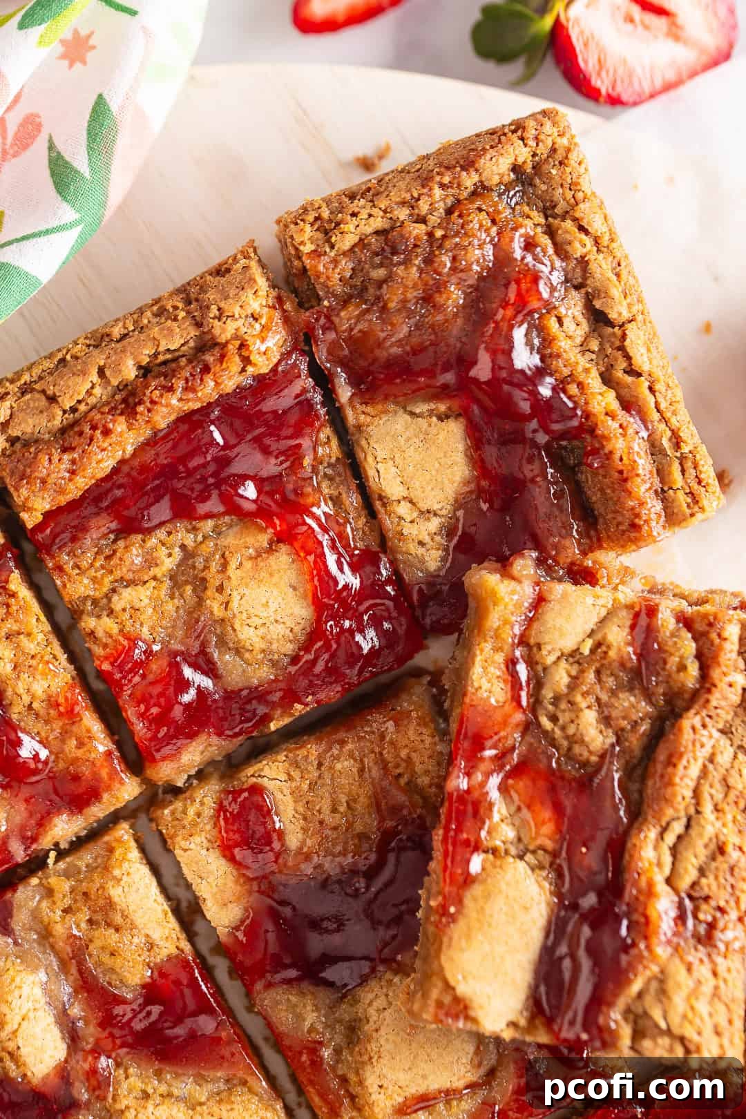 Berry Blondies cut into squares on a serving platter, showcasing their golden hue and jam swirls.