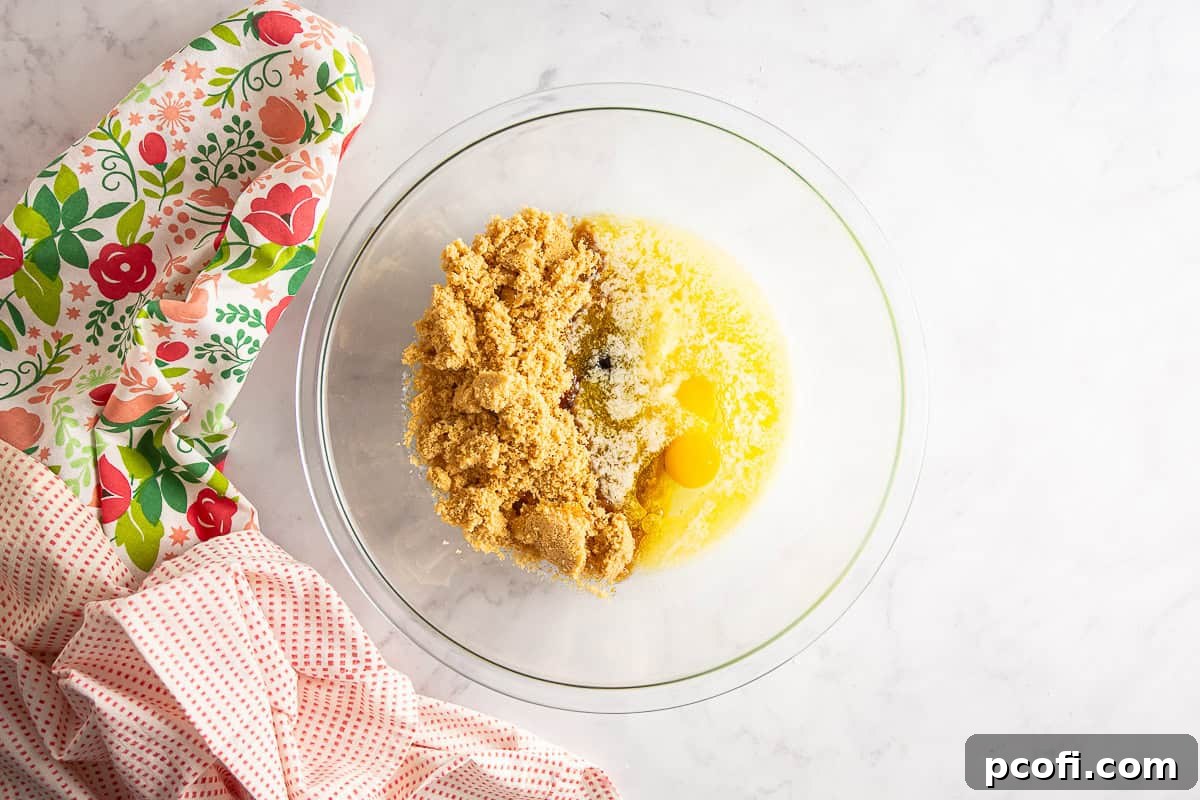 Mixing together wet ingredients for berry blondies in a large bowl with a whisk.