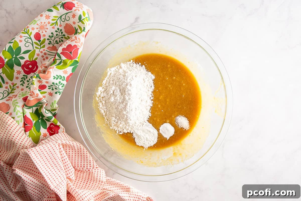 Dry ingredients like flour, baking powder, baking soda, and salt added to the mixing bowl for berry blondies.