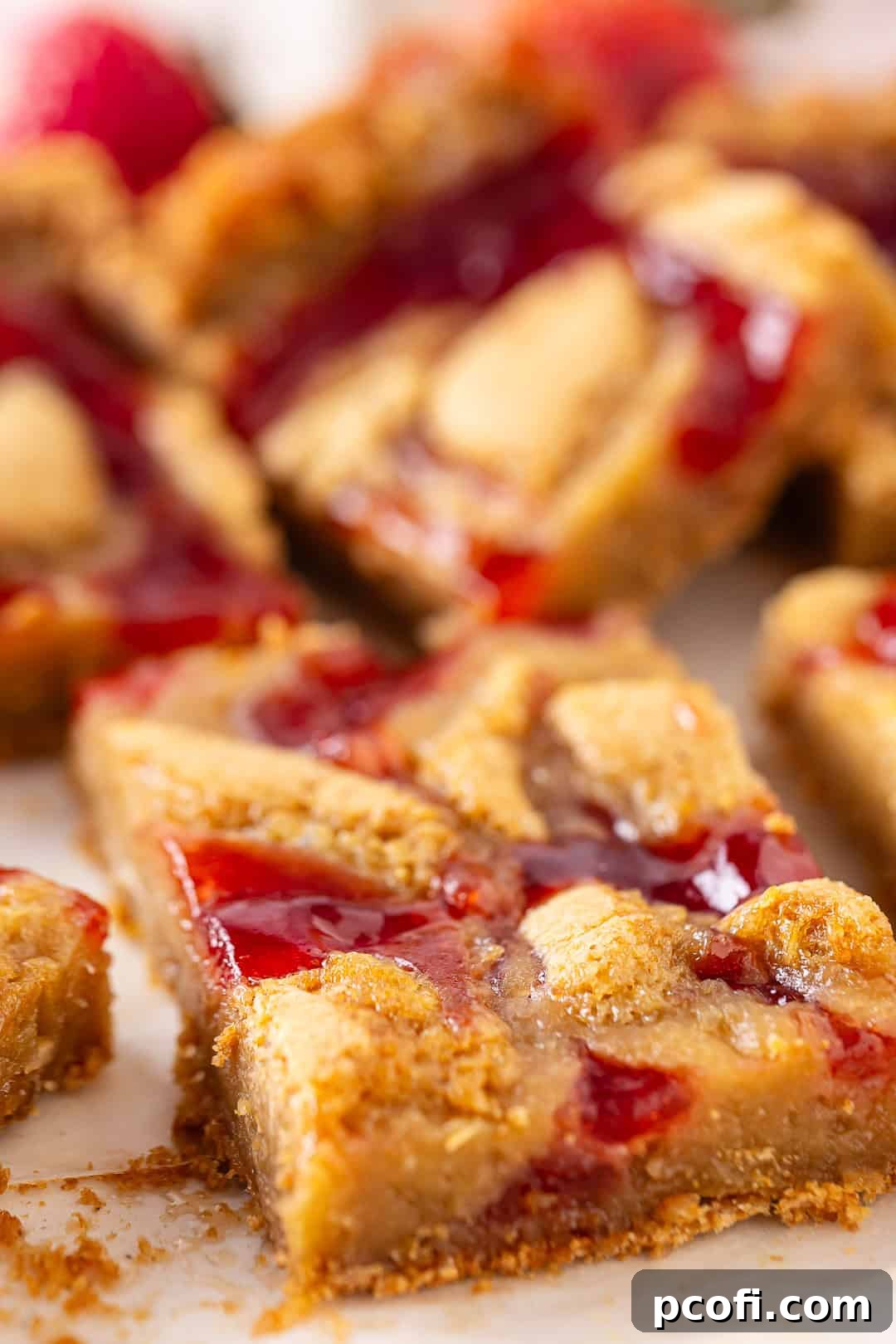 Berry blondies cut into perfect squares, arranged on a serving board with fresh strawberries in the background.