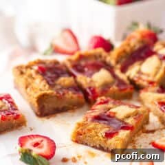 A close-up of a single Berry Blondie square, showcasing the jam swirl and chewy texture.