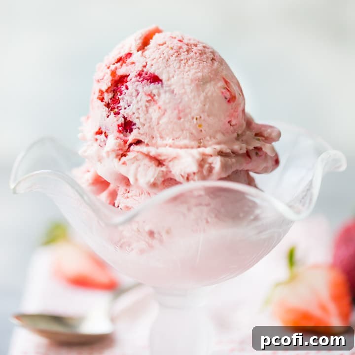 Homemade strawberry ice cream from scratch, emphasizing its creamy texture and fresh berry chunks.