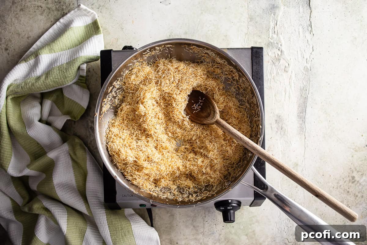 Golden brown kataifi being carefully toasted in a skillet, demonstrating the even browning required for Dubai chocolate's crispy filling.