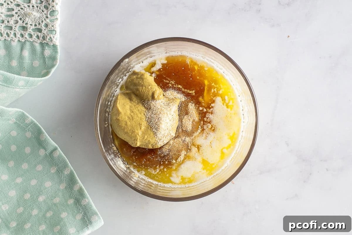 Individual ingredients for the ham and cheese croissant glaze, including butter, brown sugar, Dijon mustard, honey, and onion powder, displayed before being mixed.