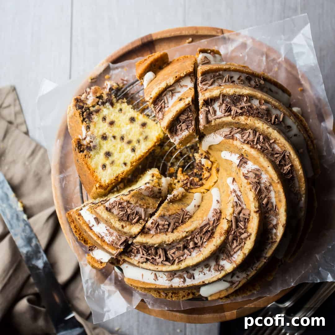 Overhead view of a chocolate chip bundt cake with vanilla glaze and dark chocolate shavings.