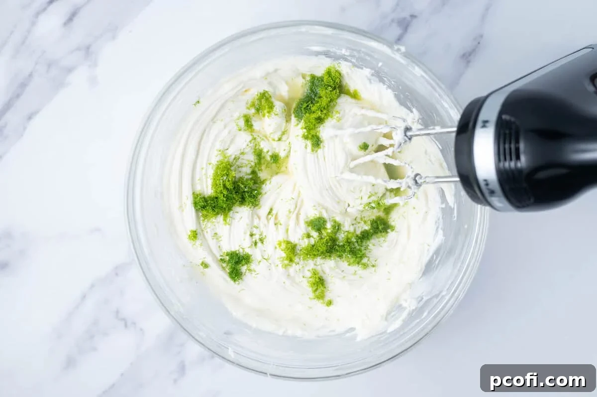 lime zest added to cheesecake filling in a bowl