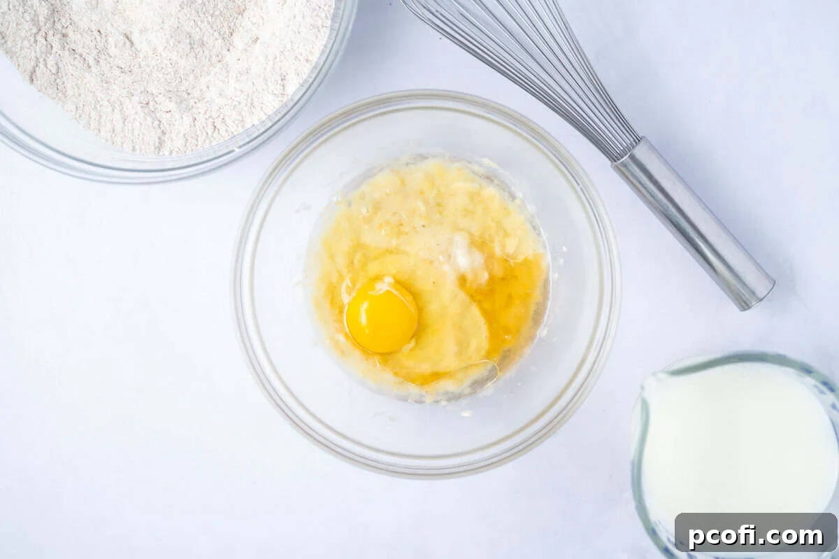 mashed banana, egg and vanilla in a glass bowl